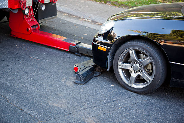 Car jack lifting a vehicle with safety precautions in place.