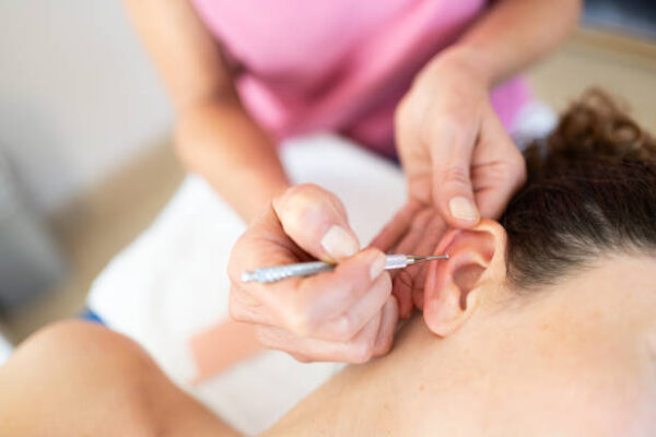 Apadravya piercing close-up with surgical tools in a sterile environment.