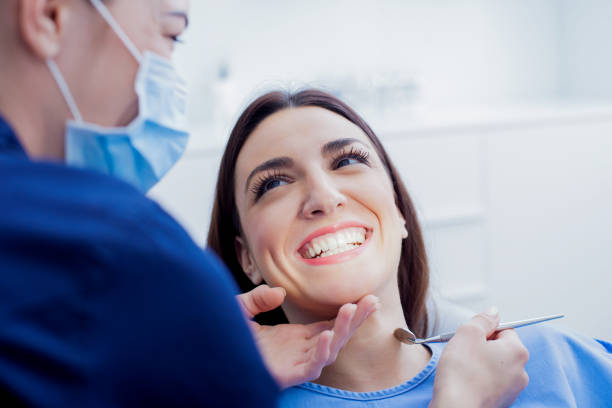 A dentist explaining Covered by Dental Insurance to a patient in a clinic.